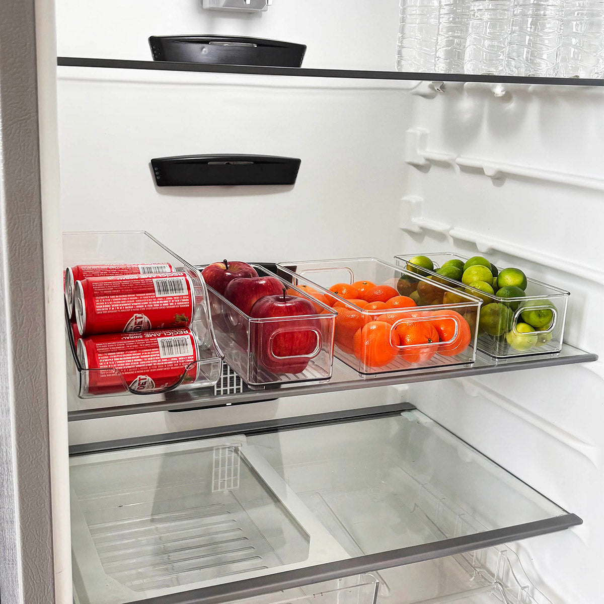 Organizadores de acrilico transparente dentro de un refrigerador clasificando frutas y verduras para maximizar el espacio y mantener el orden visual