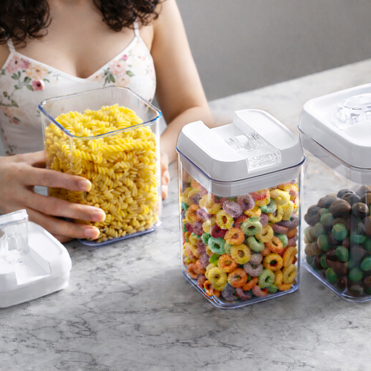 Persona que es organizada profesionalmente con contenedores transparentes y botes de cocina apilables