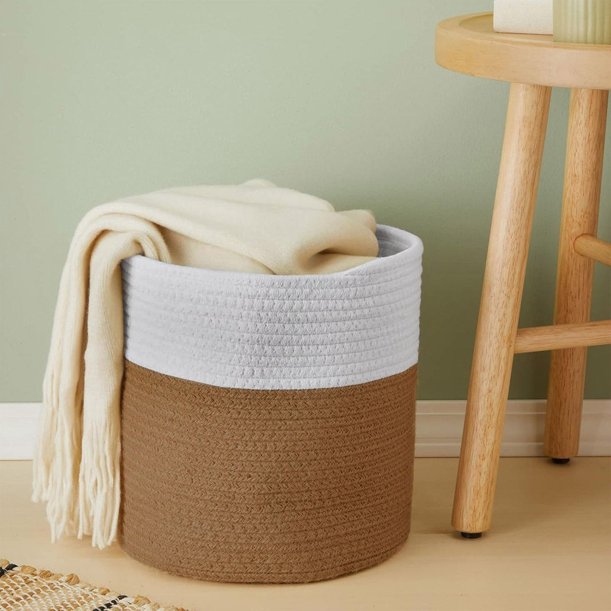 Cesto decorativo de estilo nordico utilizado para organizar mantas y cobijas en una sala de estar